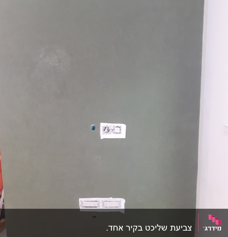 קיר צבוע בצבע ירוק עם חורים ופתחים